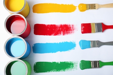 Flat lay composition with paint cans and brushes on white background