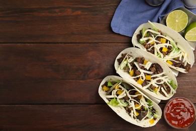 Delicious tacos with fried meat, cheese and lime on wooden table, flat lay. Space for text