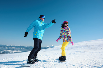 Couple snowboarding on snowy hill. Winter vacation