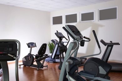 Elliptical trainers, recumbent bike and treadmill in gym. Modern sport equipment