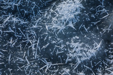 Photo of Hoarfrost crystals on icy surface, closeup view