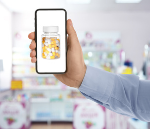 Image of Man with smartphone ordering medications online, closeup