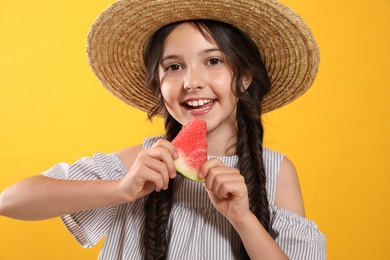 Cute little girl with watermelon on yellow background