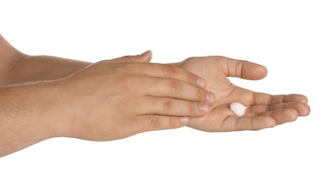 Man applying cream on hands against white background, closeup