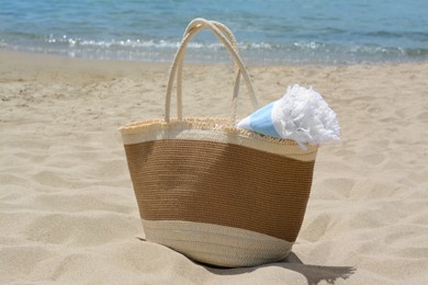 Bag with beach towel on sandy seashore