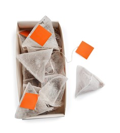 Paper tea bags with tags and box on white background, top view