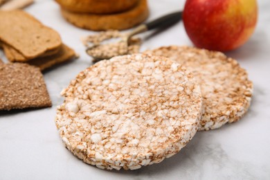 Rice cakes and rusks on white marble table, closeup