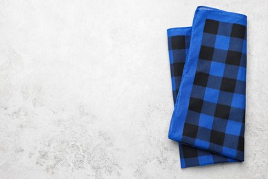 Folded blue checkered bandana on white table, top view. Space for text