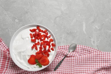 Delicious yogurt with strawberries served on grey marble table, flat lay. Space for text