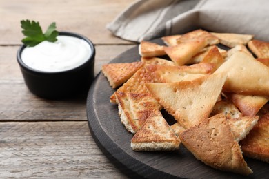 Delicious pita chips on wooden table, closeup
