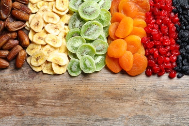 Different dried fruits on wooden background, top view with space for text. Healthy lifestyle