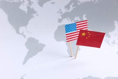 American and Chinese flags on world map, space for text. Trade war concept