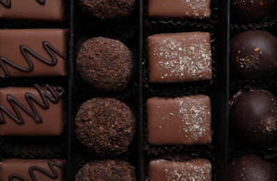 Different delicious chocolate candies in box, top view