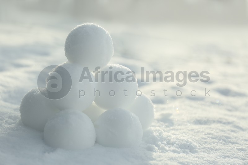 Pyramid of perfect snowballs on snow outdoors, closeup