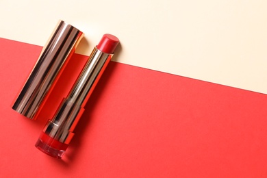 Red lipstick on color background, top view. Space for text
