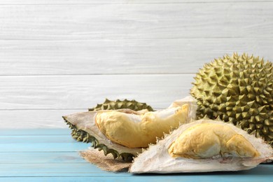 Fresh ripe durians on light blue wooden table. Space for text