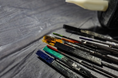 Tattoo needles covered with colorful inks on table, closeup. Space for text