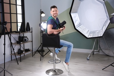 Professional photographer with camera and lighting equipment in studio