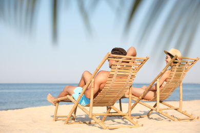 Photo of Couple resting on sunny beach at resort