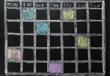 Weekly school timetable drawn with colorful chalk on blackboard