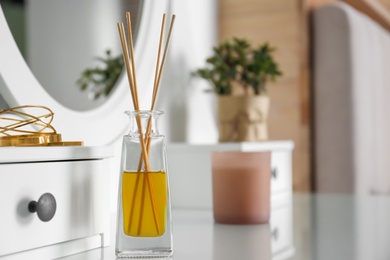 Aromatic reed air freshener on dressing table indoors. Space for text
