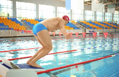 Young athletic man jumping in swimming pool