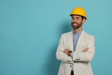 Photo of Professional engineer in hat on light blue background, space for text