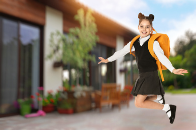 Image of Happy girl jumping near house, space for text. School holidays