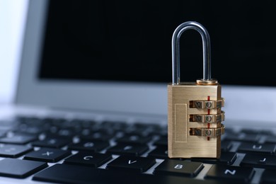 Photo of Metal code padlock on laptop keyboard, space for text. Cyber security concept