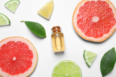 Flat lay composition with bottle of citrus essential oil on white background