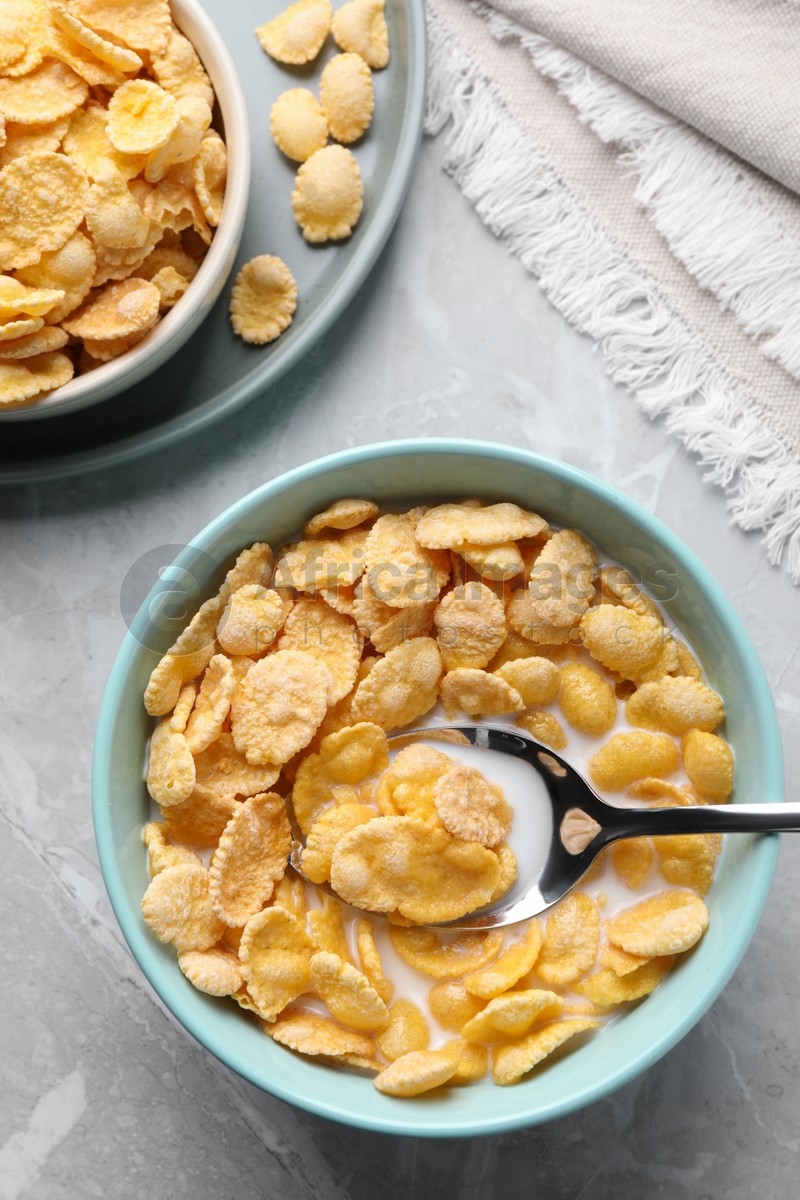 Tasty cornflakes with milk served on light grey table, flat lay