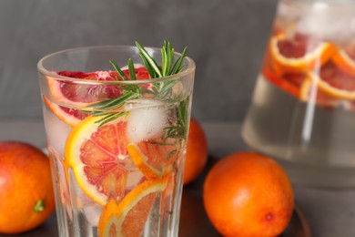Delicious refreshing drink with sicilian orange and rosemary near fresh ingredients on table, closeup