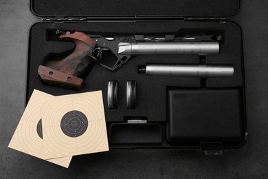 Case with sport pistol and accessories on black table, top view. Professional gun