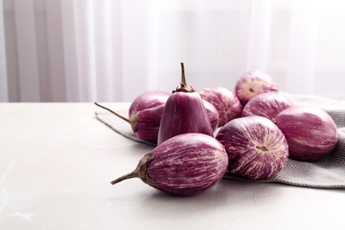 Photo of Raw ripe eggplants on light table. Space for text