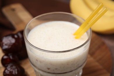 Photo of Glass of delicious date smoothie on board, closeup