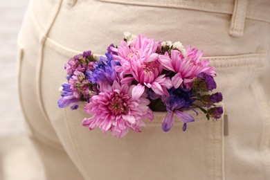 Woman wearing jeans with flowers in pocket, closeup