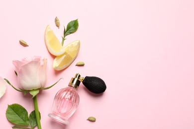 Flat lay composition with elegant perfume on pink background, space for text