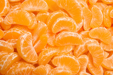 Fresh juicy tangerine segments as background, top view