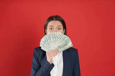 Young woman with money on crimson background
