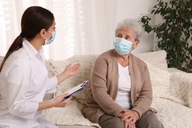Doctor examining senior woman with protective mask at nursing home