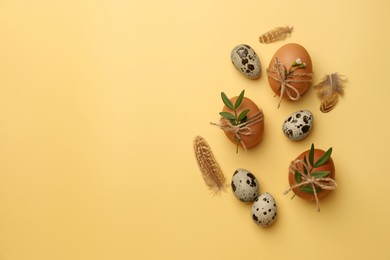 Photo of Happy Easter. Chicken and quail eggs with natural decor on yellow background, flat lay. Space for text