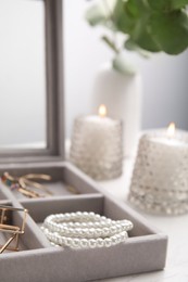 Elegant jewelry box with beautiful bijouterie on table, closeup