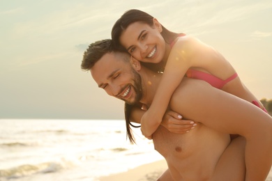 Happy young couple having fun on beach on sunny day