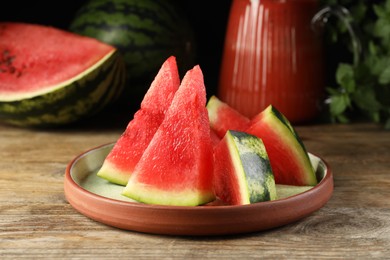 Plate with slices of juicy watermelon on wooden table