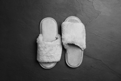 Pair of soft slippers on dark grey floor, top view