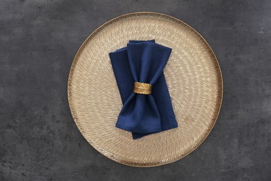 Tray with blue napkins and decorative ring on grey table, top view
