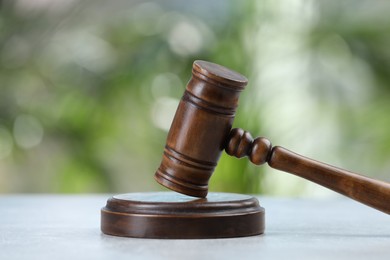 Wooden gavel on grey table against blurred background