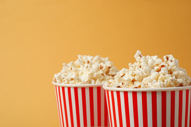 Delicious popcorn in paper cups on yellow background, closeup