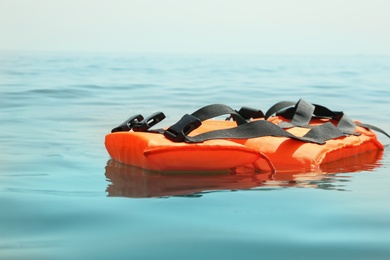 Orange life jacket floating in sea. Emergency rescue equipment