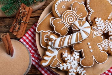 Delicious gingerbread Christmas cookies on wooden table, flat lay